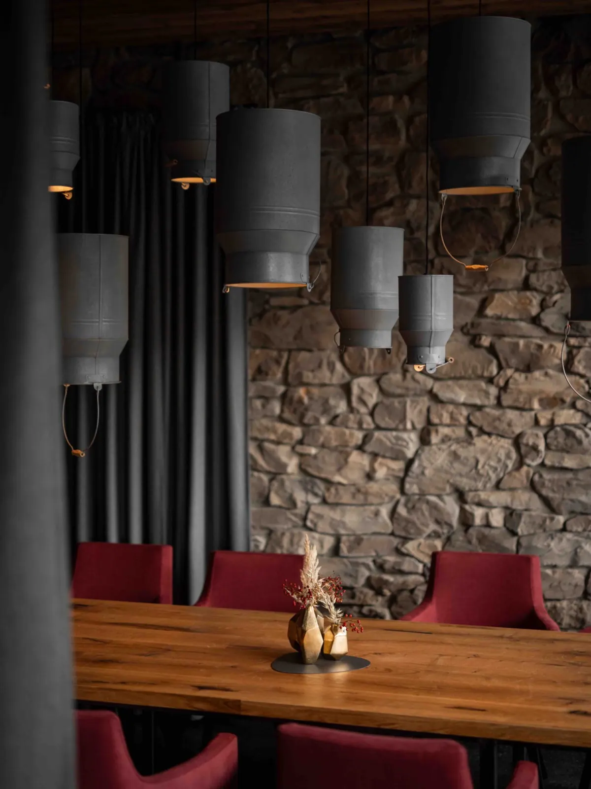 Restaurant der ADEA Lifestyle Suites Fieberbrunn mit Natursteinwand und Holztisch